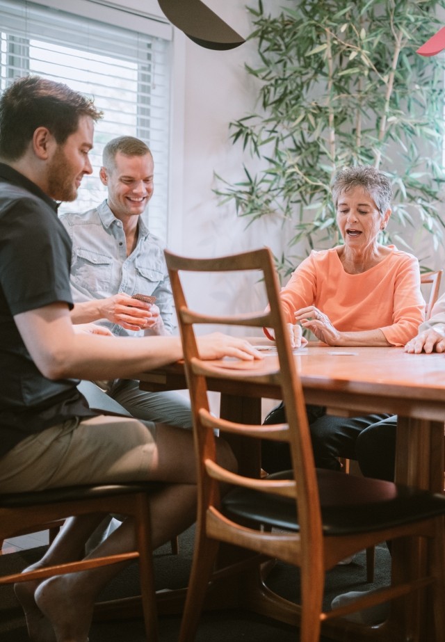 A family sitting at a table talking and laughing