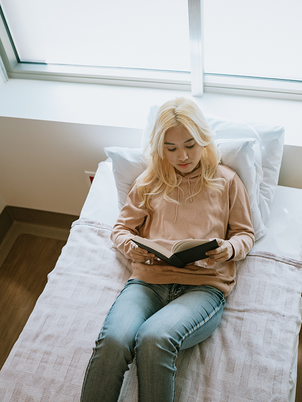 A patient reads in her room in residential or inpatient treatment
