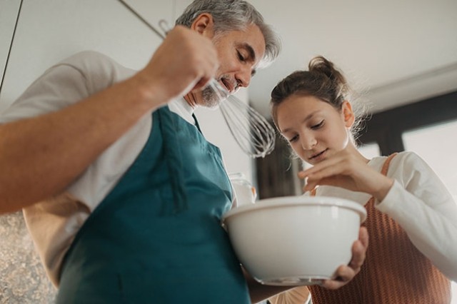 Father and daughter in kitchen baking