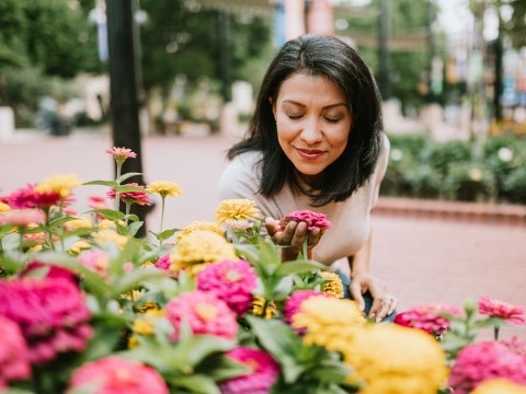 A woman smells flowers outdoors